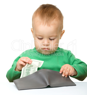 Cute little boy is counting money
