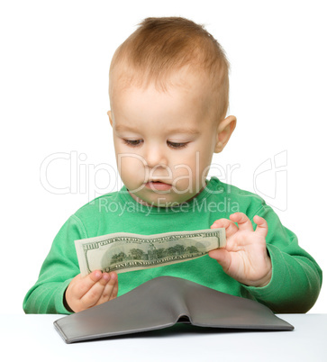 Cute little boy is counting money