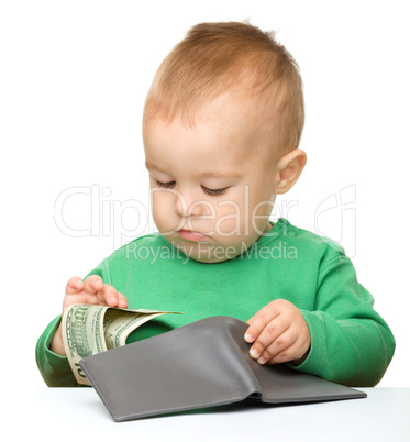 Cute little boy is counting money