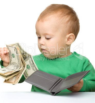 Cute little boy is counting money