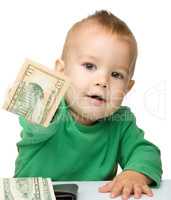 Cute little boy is counting money