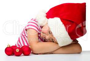 Cute little girl is sleeping wearing santa hat
