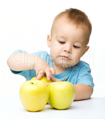 Portrait of a cute little boy with yellow apples