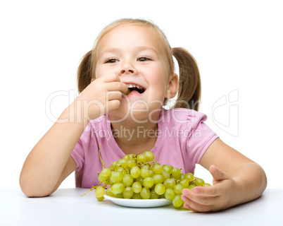 Little girl is eating grapes