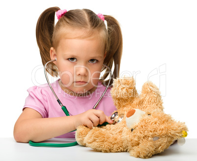 Little girl is playing with her teddy bear