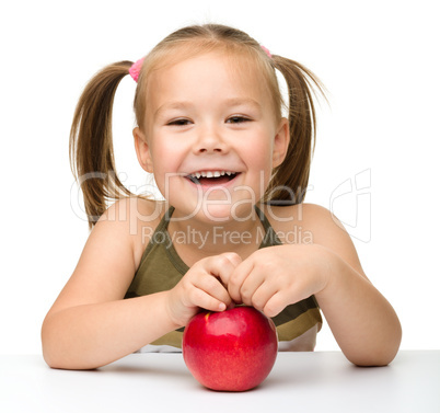 Portrait of a cute little girl with red apple