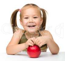 Portrait of a cute little girl with red apple