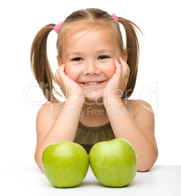 Little girl with two green apples