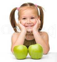 Little girl with two green apples