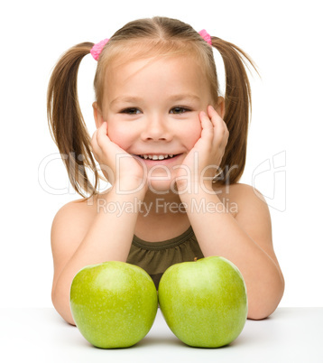 Little girl with two green apples