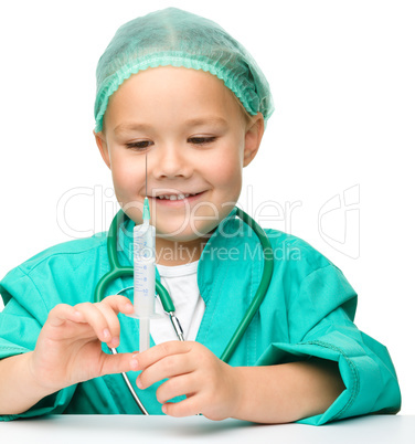 Little girl is playing doctor with syringe