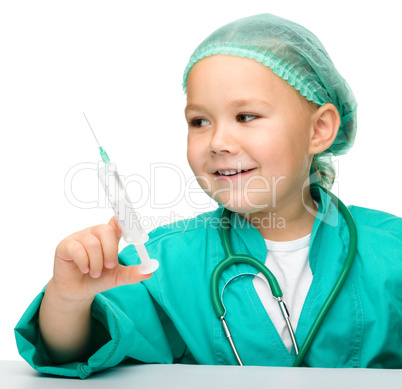 Little girl is playing doctor with syringe