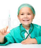 Little girl is playing doctor with syringe