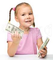 Cute little girl with paper money - dollars