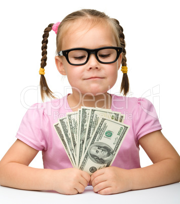 Cute cheerful little girl with paper money