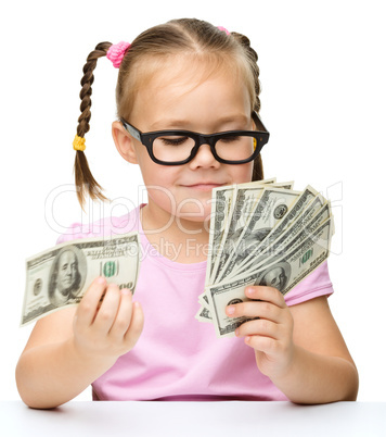 Little girl is counting dollars