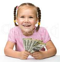 Cute cheerful little girl with paper money