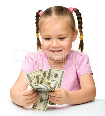 Cute little girl is counting dollars