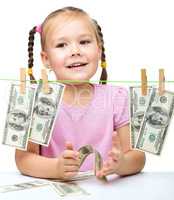 Cute little girl is playing with paper money