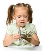 Cute little girl with paper money - dollars