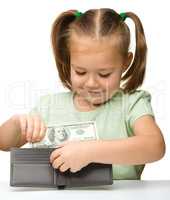 Cute little girl plays with money