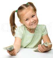 Cute little girl with paper money - dollars