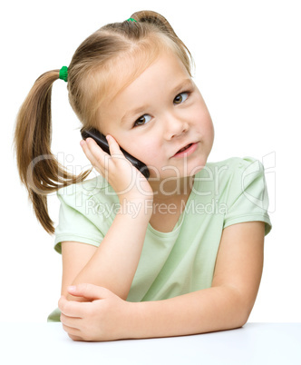 Cute little girl is talking on a cell phone