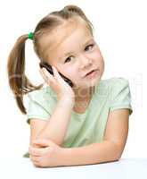 Cute little girl is talking on a cell phone