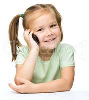 Cute little girl is talking on a cell phone