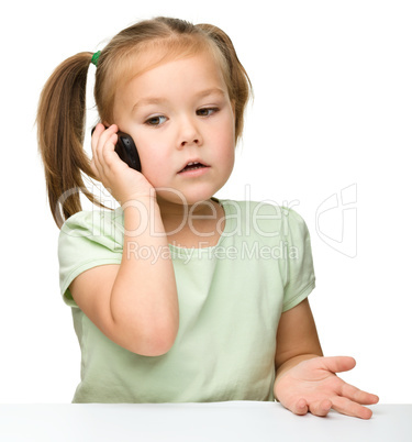 Cute little girl is talking on a cell phone