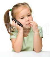 Cute little girl is talking on a cell phone