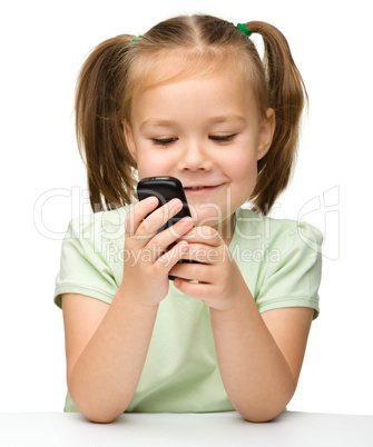 Cute little girl is playing with cell phone