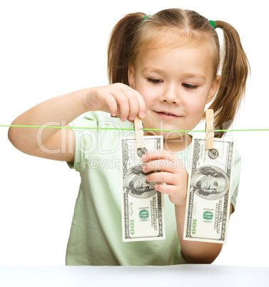 Cute little girl is playing with paper money