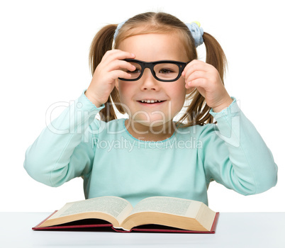 Cute little girl reads a book