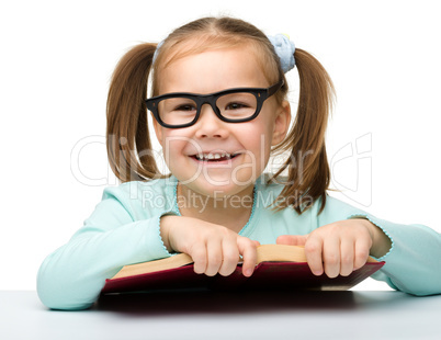 Cute little girl reads a book