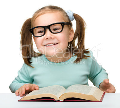 Cute little girl reads a book