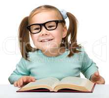 Cute little girl reads a book