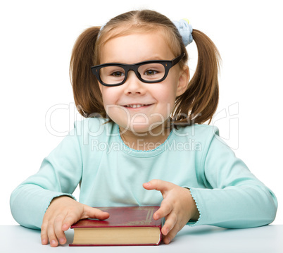 Happy little girl with book wearing black glasses