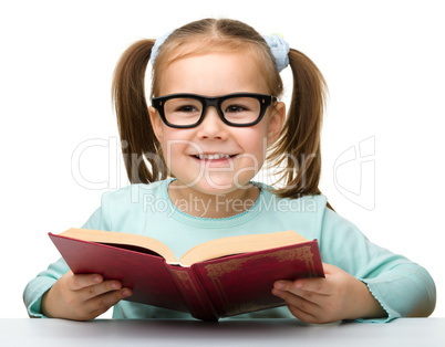 Cute little girl reads a book