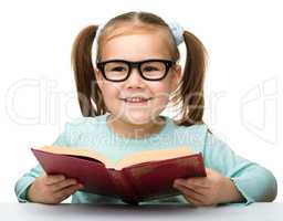 Cute little girl reads a book