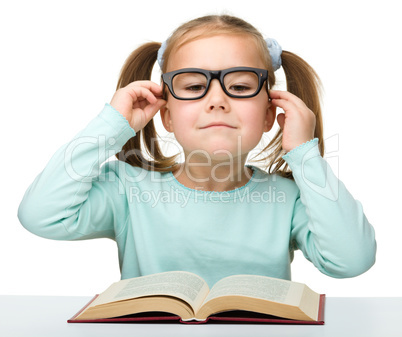 Cute little girl reads a book