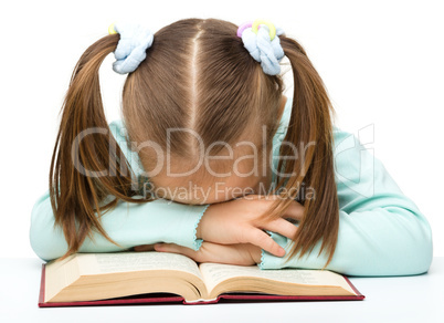 Cute little girl is sleeping on a book