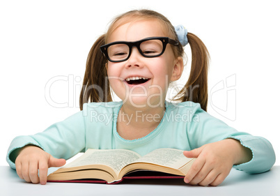 Cute little girl reads a book