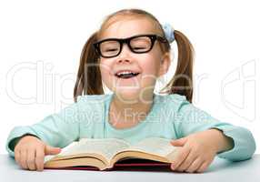 Cute little girl reads a book