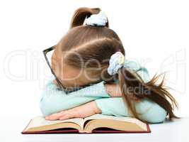 Little girl is sleeping on a book