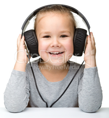 Cute girl enjoying music using headphones