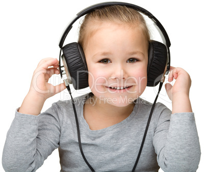 Cute girl enjoying music using headphones