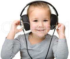 Cute girl enjoying music using headphones