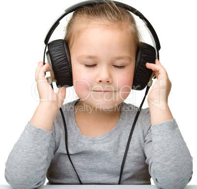 Cute girl enjoying music using headphones