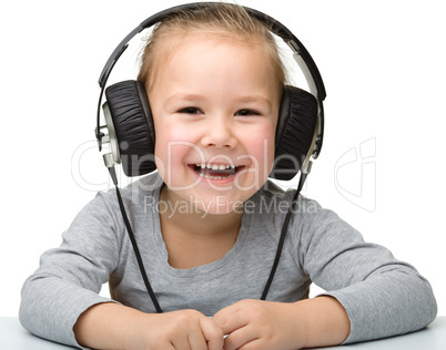 Cute girl enjoying music using headphones